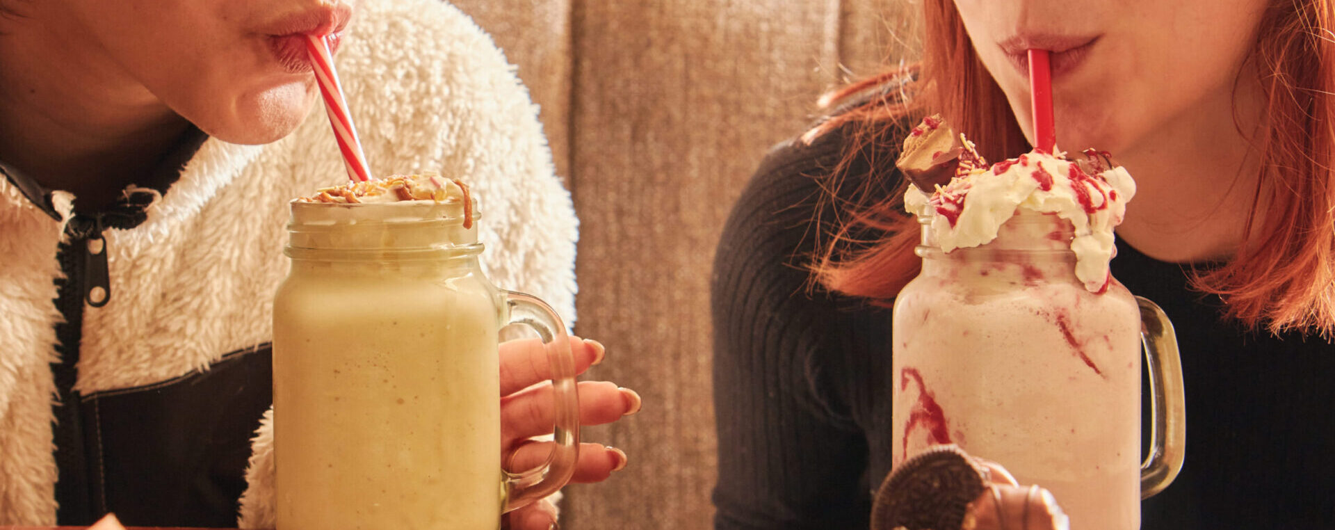 Two girls drinking a milkshake.