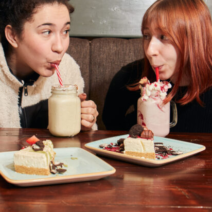 Two girls drinking a milkshake.