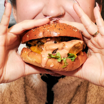 A girl biting a hamburger.