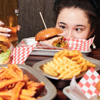 A girl looking at a hamburger.