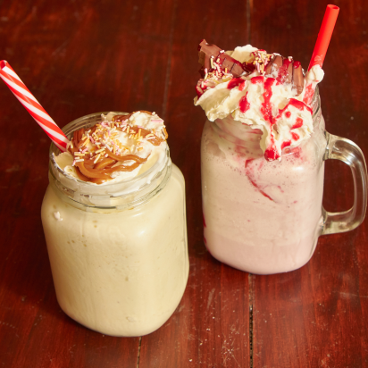 Two milkshakes on a table.