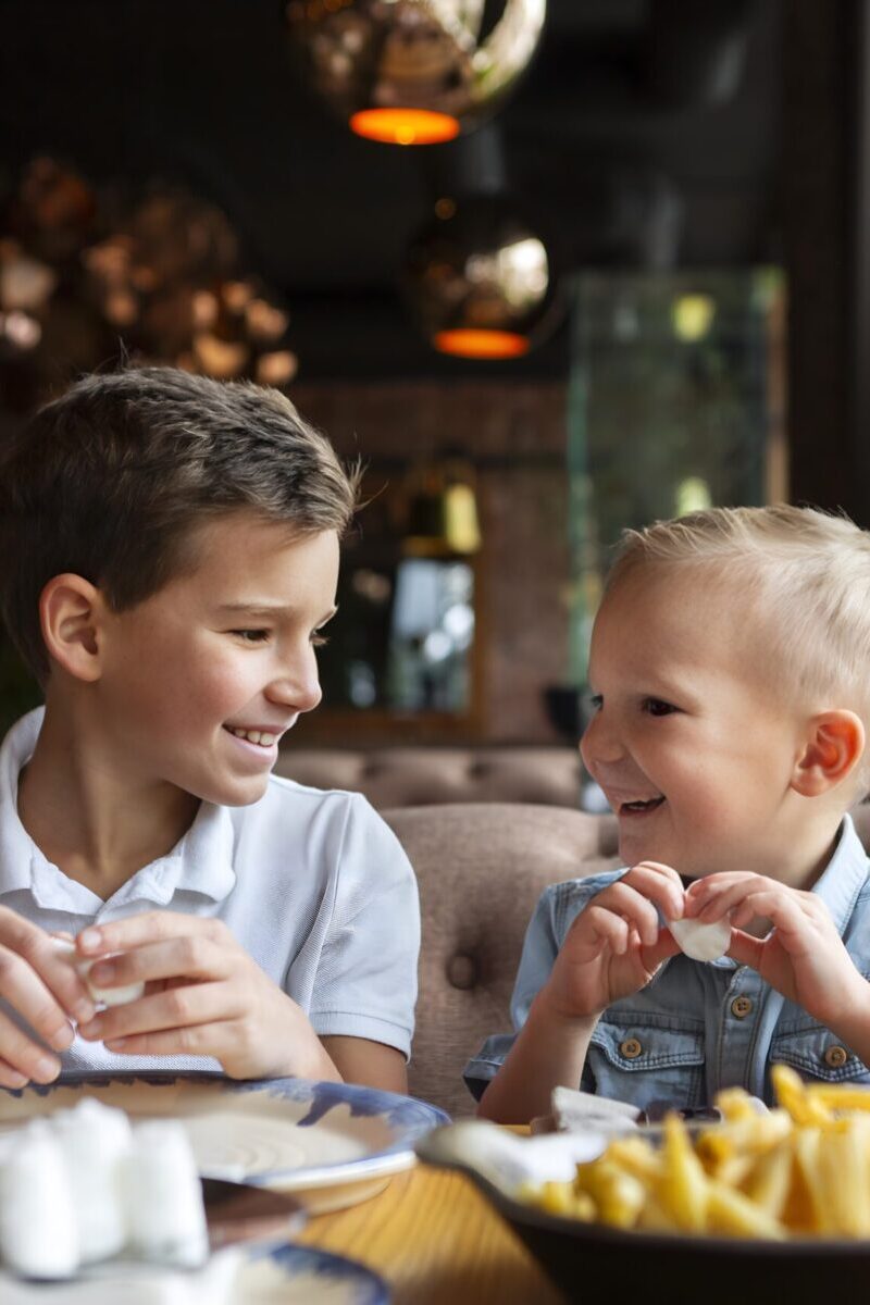 Two kids eating and smiling.