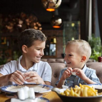 Two kids eating and smiling.